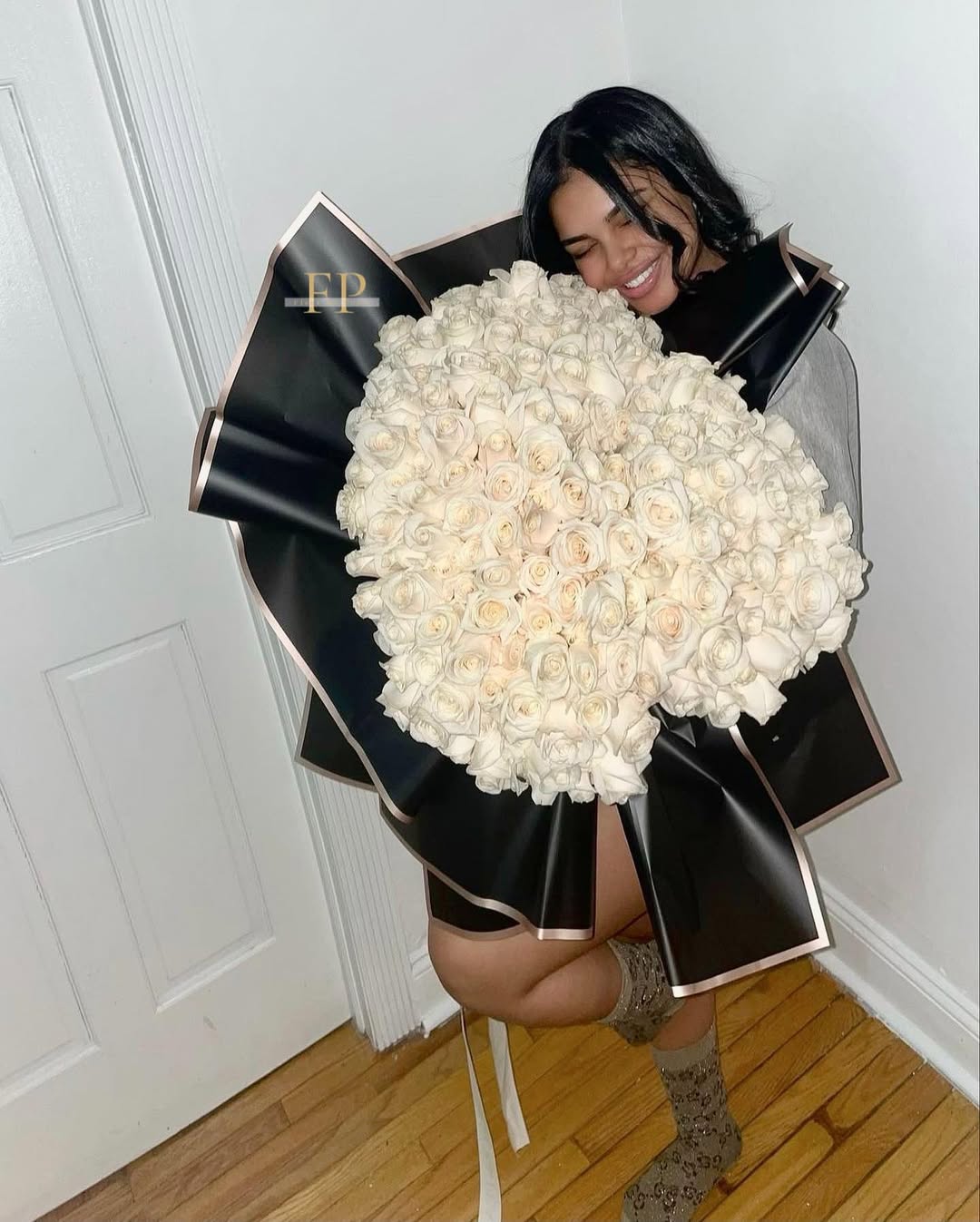 Joyful client with large white rose bouquet