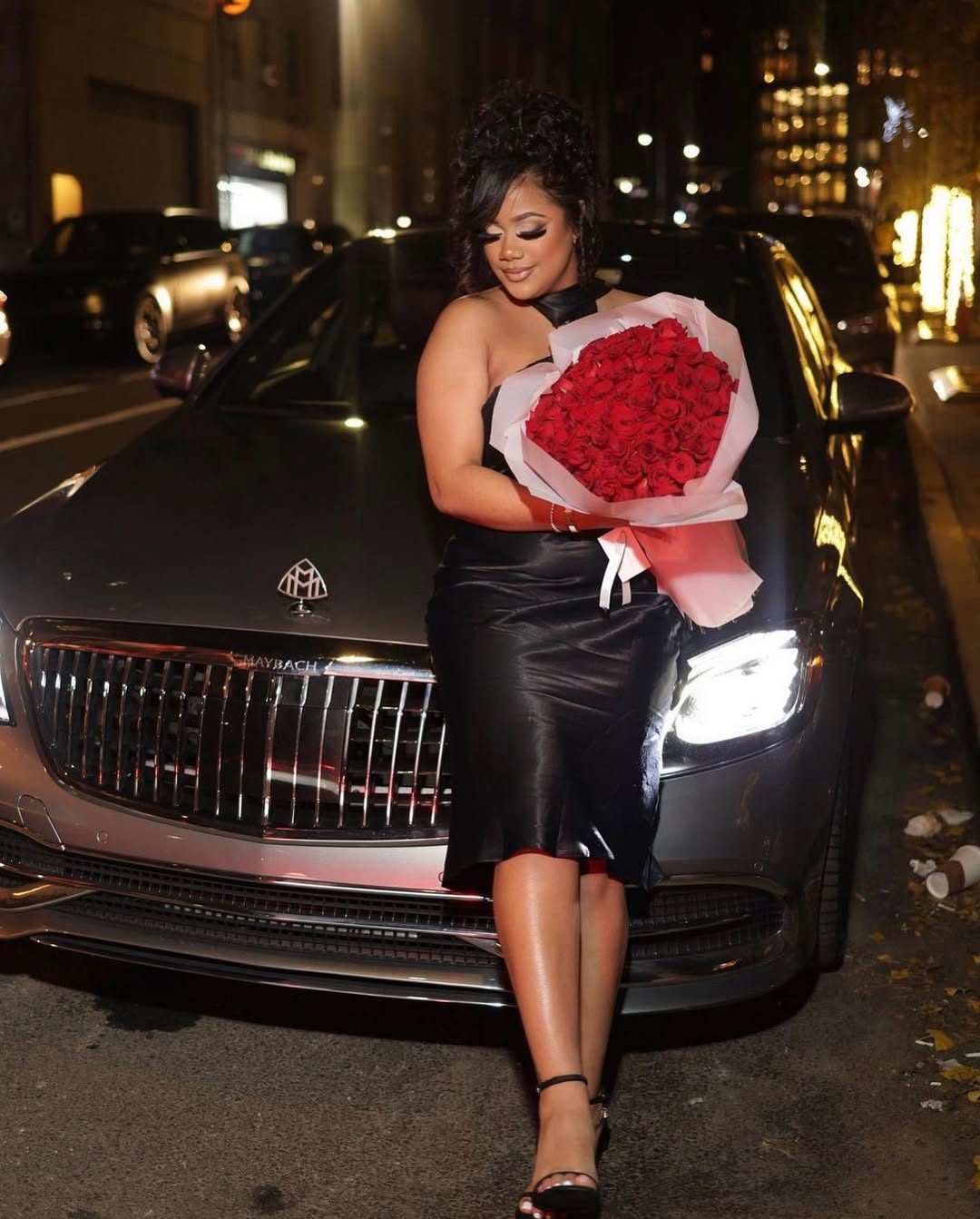 Stylish client with red roses next to luxury vehicle